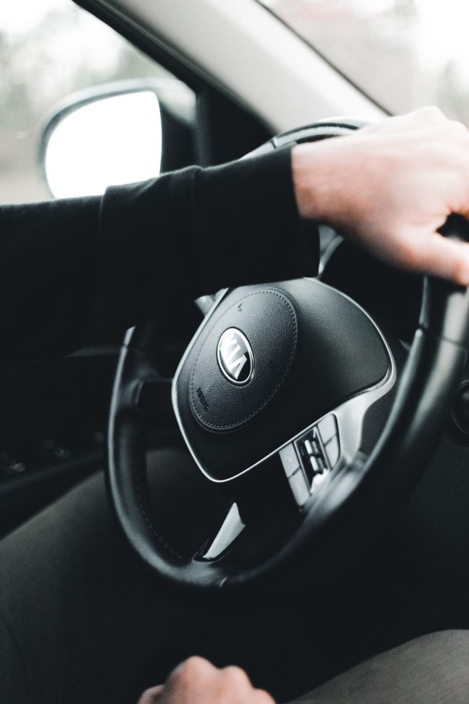 Close view of hands holding a car steering wheel