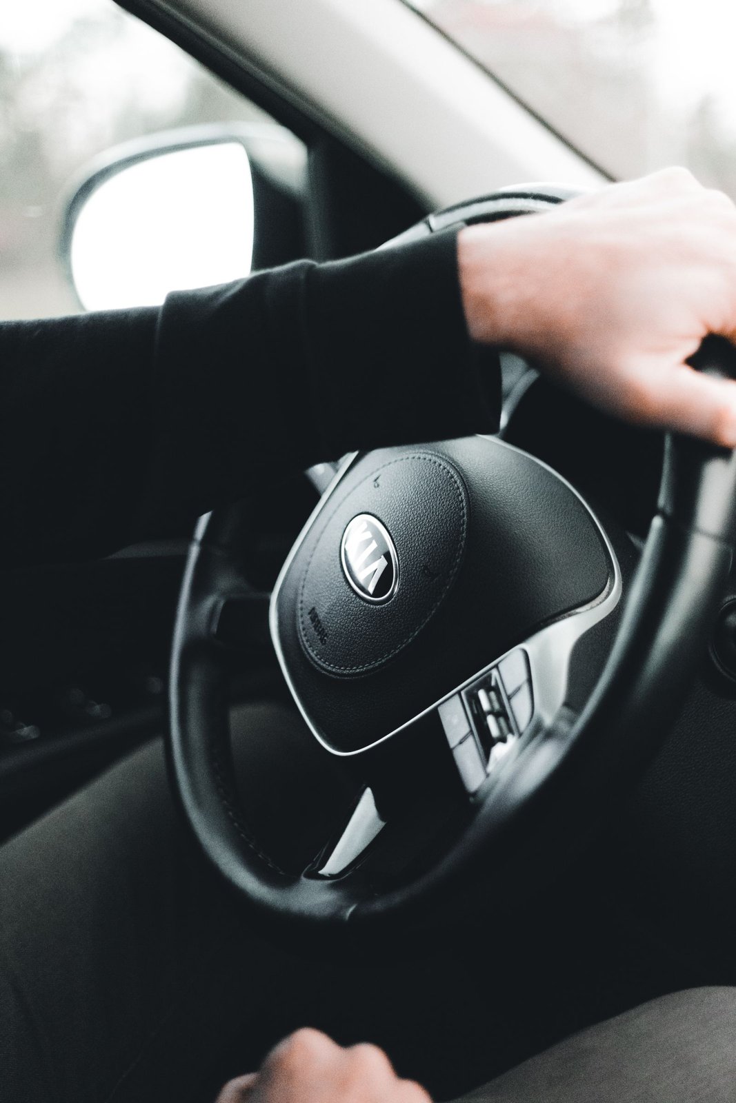 Close view of hands holding a car steering wheel